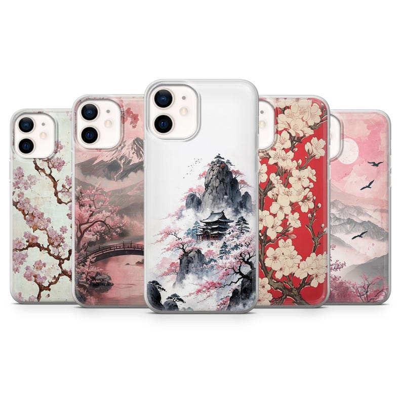 May include: Five phone cases with Japanese-style art. Designs include cherry blossom branches, mountain scenes, and temples. The cases display pink, red, and white colour schemes, with detailed illustrations of landscapes and nature.