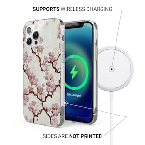 May include: A clear phone case with a floral design of pink blossoms and brown branches. The phone screen shows a charging symbol. Text reads "SUPPORTS WIRELESS CHARGING" and "SIDES ARE NOT PRINTED".