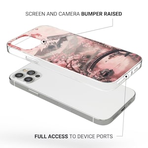 May include: Clear phone case with a pink and white landscape design featuring a bridge, trees, and mountains. The case is over a silver phone, with the text "SCREEN AND CAMERA BUMPER RAISED" and "FULL ACCESS TO DEVICE PORTS".