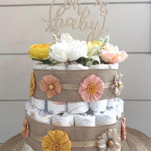 Torta di pannolini a due piani con fiori multicolori, regalo per baby shower o centrotavola