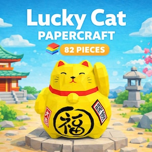 Puede incluir: Un Lucky Cat de papel amarillo con un collar rojo y un emblema negro y dorado. La imagen incluye el texto "Lucky Cat Papercraft" y "82 piezas". El fondo presenta una pagoda japonesa, flores de cerezo y una linterna de piedra.