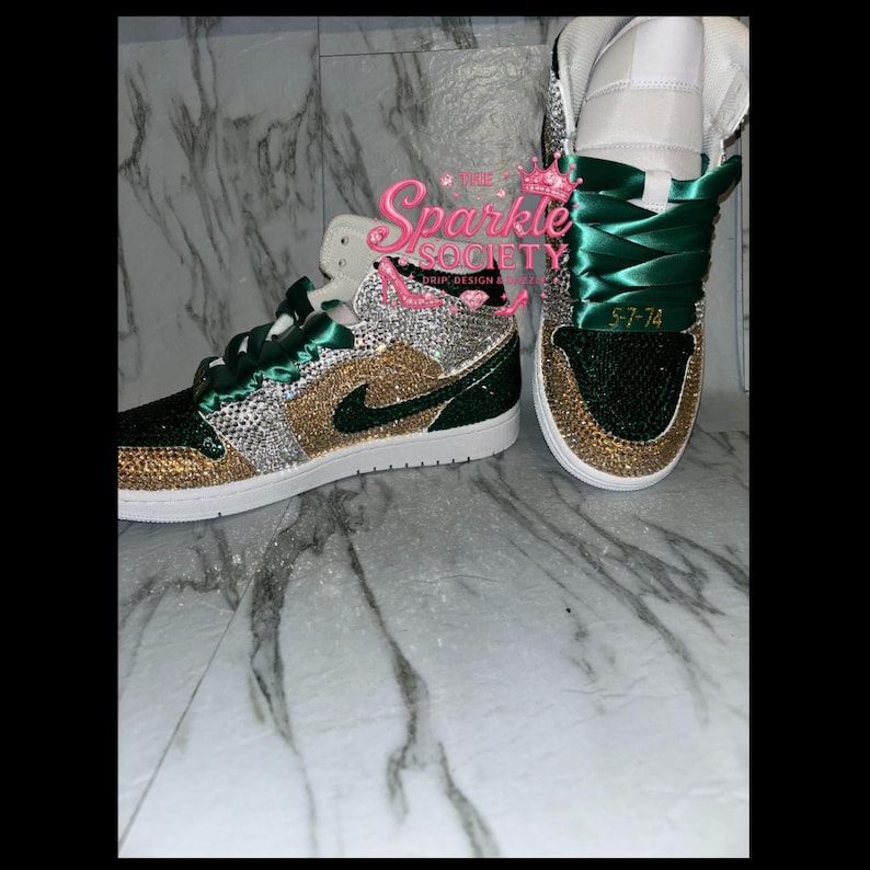 Puede incluir: Zapatillas altas con un dise&ntilde;o verde, dorado y plateado. Los zapatos presentan una suela blanca, cordones verdes y una parte superior enjoyada. El texto "Sparkle Society" es visible en el lateral del zapato.