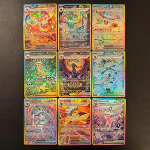May include: A collection of nine holographic Pokemon trading cards arranged in a three-by-three grid. Each card features a unique character illustration with vibrant colors, metallic foil details, text, and numerical power ratings.
