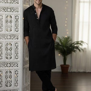 May include: Black kurta pajama set with intricate embroidery. The long-sleeved kurta features a mandarin collar and button-down front. The matching pajama pants complete the ensemble. The brand name "SHIFACRAFTDESIGN" is visible in the image.