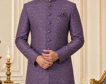 Può includere: Uno sherwani viola con colletto alla coreana, maniche lunghe e abbottonatura frontale con bottoni rivestiti in tessuto coordinato. Il capo è decorato con un intricato motivo geometrico e sottili decorazioni di paillettes su tutta la superficie.