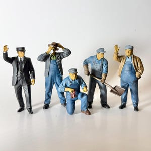 May include: A collection of miniature figurines depicting various workers. The figures include a man in a suit, and several men in overalls, some holding tools. The color palette includes shades of blue, brown, and black.