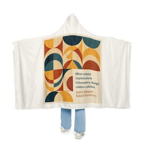 Könnte beinhalten: Eine weiße Kapuzendecke mit einem zentralen Grafikdruck aus geometrischen Formen in Marineblau, Senfgelb und Terrakotta-Rot. Der Text lautet: Mirst misist coplenctiow colouutery design. colders coloton. Jusrct Miopan Aidant Ryenttury.
