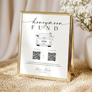 May include: A framed sign with a gold border, featuring the words "honeymoon FUND" in elegant script. Below, a line drawing of a car with a "Just Married" sign. Includes QR codes for Venmo and CashApp, and the names Olivia & David.