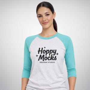 Next Level 6051 raglanmockup • Tahiniblauw/wit gemêleerd • NL6051 honkbal-T-shirt met 3/4-mouwen • Vrouwelijk model • Minimalistisch studiomodel