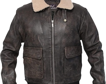 May include: A distressed brown leather jacket with a cream-colored shearling collar. The jacket features a zip-up front, two front pockets, and a black ribbed hem and cuffs. The label reads "Real Leather Garments".