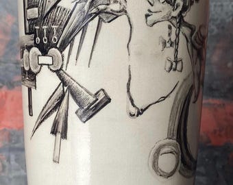Könnte beinhalten: Keramikvase mit blauem Rand und Boden, mit einer skurrilen Schwarz-Weiß-Illustration. Das Kunstwerk zeigt eine mechanische Figur, die mit einer Person interagiert. Die Vase hat einen cremefarbenen Körper.
