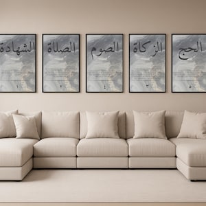 Peut inclure: Cinq impressions d'art encadrées avec calligraphie arabe sont accrochées au-dessus d'un canapé sectionnel beige. Les impressions présentent des arrière-plans abstraits et du texte noir. Le canapé a plusieurs coussins beiges. Une plante en pot se trouve à droite du canapé.