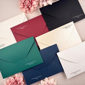 May include: A selection of 5x7 cm envelopes in diverse colours, such as white, black, burgundy, navy, and sage green. Each envelope is presented with a matching flower and features printed text on the front.