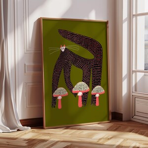 May include: A black cat with pink polka dots stands on a green background with three white and red mushrooms. The cat has a long tail and large eyes.