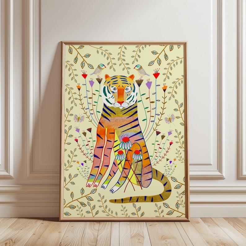 Puede incluir: Una impresi&oacute;n de arte mural vertical enmarcada que presenta un tigre estilizado en tonos naranja, amarillo y azul. El tigre est&aacute; rodeado de tallos florales coloridos, p&aacute;jaros peque&ntilde;os y mariposas sobre un fondo amarillo p&aacute;lido con hojas.