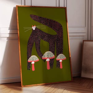 May include: A black cat with pink polka dots stands on a green background with three red and white mushrooms. The cat has a white face with pink cheeks and black eyes.