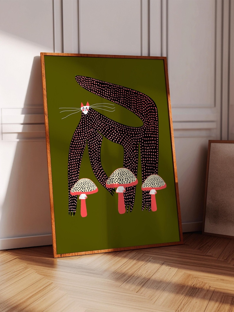 May include: A black cat with pink polka dots stands on a green background with three red and white mushrooms. The cat has a white face with pink cheeks and black eyes.
