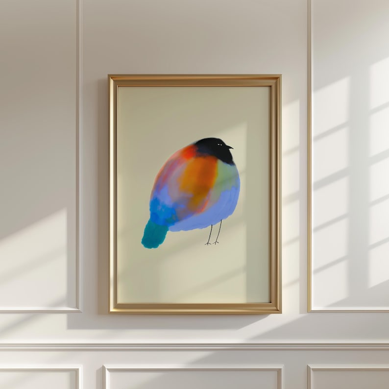 May include: A framed wall art print featuring a stylised, round bird illustration. The bird has a solid black head, a vibrant body with blended patches of orange, red, and blue, and a teal tail. It stands on thin, simple black line legs.