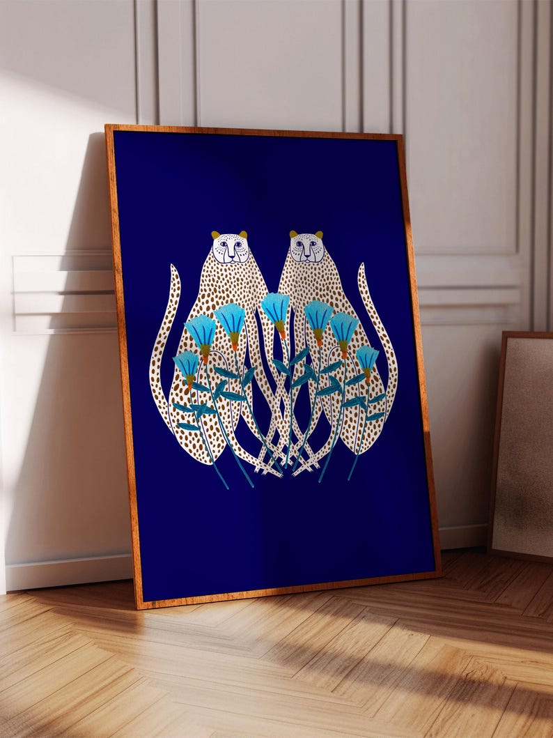Puede incluir: Dos guepardos blancos con manchas negras se representan en un dise&ntilde;o sim&eacute;trico sobre un fondo azul oscuro. Los guepardos est&aacute;n mirando hacia adelante y est&aacute;n rodeados de flores azules con centros amarillos.