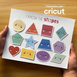 May include: A white sheet with colorful, smiling shape stickers, including a circle, triangle, square, and star. The text "I KNOW THE shapes" is printed at the top, with "Compatible with Cricut" above. The sheet is held by hands.