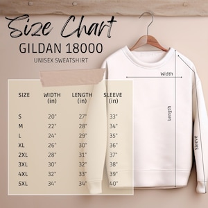 K&ouml;nnte beinhalten: Ein wei&szlig;es Gildan 18000 Unisex-Sweatshirt h&auml;ngt an einem Holzb&uuml;gel. Eine Gr&ouml;&szlig;entabelle zeigt die Ma&szlig;e in Zoll f&uuml;r Breite, L&auml;nge und &Auml;rmell&auml;nge. Gr&ouml;&szlig;en von S bis 5XL. Klassischer Rundhalsausschnitt.
