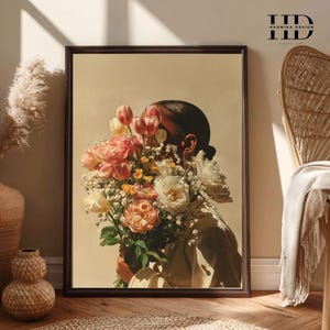 May include: A framed art print featuring a person holding a large bouquet of flowers. The flowers include pink, peach, and white roses, tulips, and other blooms. The artwork has a neutral color palette and is signed "Harmika Design".