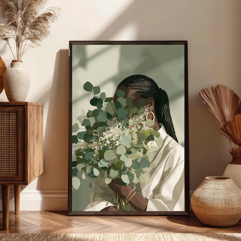 May include: A framed art print featuring a person holding a bouquet of green and white flowers, with their face partially obscured. The person is wearing a white shirt and gold hoop earrings. The artwork has a soft, muted color palette.