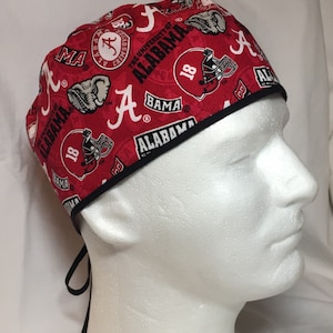 May include: Red and black scrub hat with a pattern of the University of Alabama logo, the word "Alabama", and the number "18".