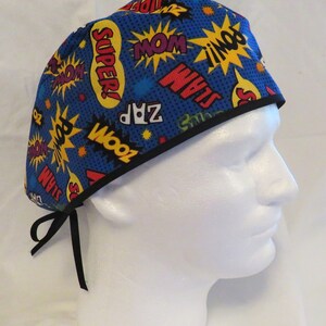 May include: Blue surgical scrub hat with a black trim and a comic book print featuring words like "Super!" and "Zoom!" in yellow and red.