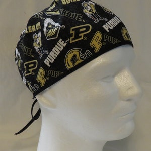 May include: Black scrub hat with a white and gold Purdue University logo pattern. The hat has a tie at the back.