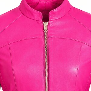 K&ouml;nnte beinhalten: Eine leuchtend pinkfarbene Jacke mit Stehkragen und einem mittigen Rei&szlig;verschluss aus silberfarbenem Metall. Das Kleidungsst&uuml;ck verf&uuml;gt &uuml;ber zwei untere Taschen mit silberfarbenen Rei&szlig;verschl&uuml;ssen und sichtbare N&auml;hte an Brust und Schultern.
