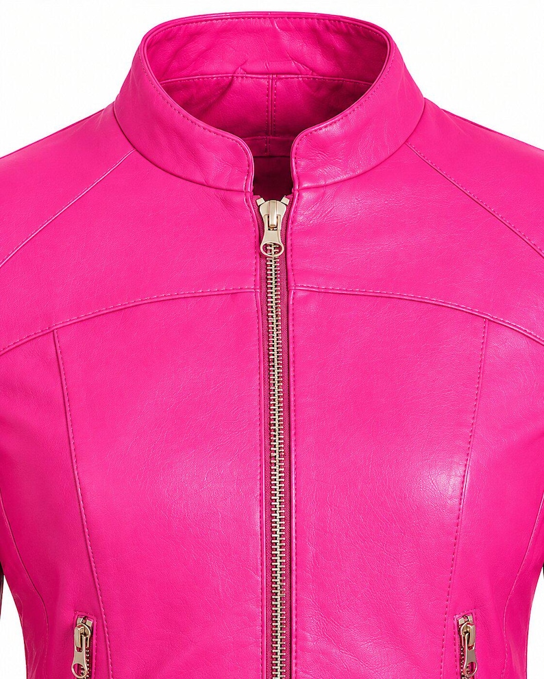 K&ouml;nnte beinhalten: Eine leuchtend pinkfarbene Jacke mit Stehkragen und einem mittigen Rei&szlig;verschluss aus silberfarbenem Metall. Das Kleidungsst&uuml;ck verf&uuml;gt &uuml;ber zwei untere Taschen mit silberfarbenen Rei&szlig;verschl&uuml;ssen und sichtbare N&auml;hte an Brust und Schultern.