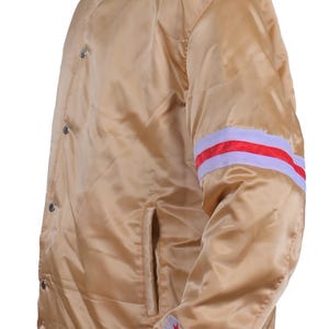 Side view of golden satin varsity jacket shiny bomber with red and white stripes and star patch on sleeve