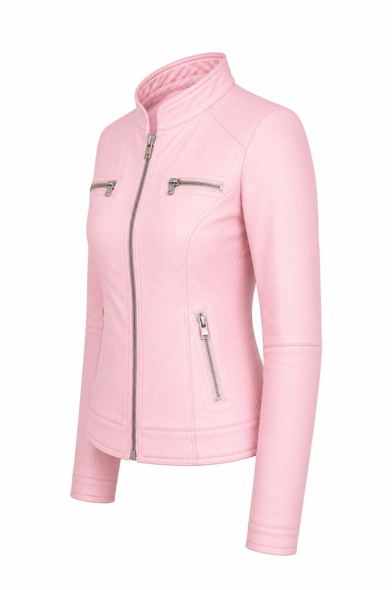 Puede incluir: Una chaqueta de color rosa claro con cuello alzado, una cremallera frontal plateada de longitud completa y dos bolsillos horizontales con cremallera en el pecho. La prenda incluye dos bolsillos verticales con cremallera en la cintura.