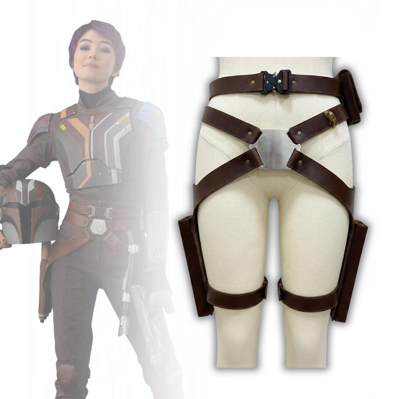 May include: Brown leather utility belt with two thigh holsters and a small pouch. The belt features a silver buckle and straps that cross the front. The belt is displayed on a mannequin.