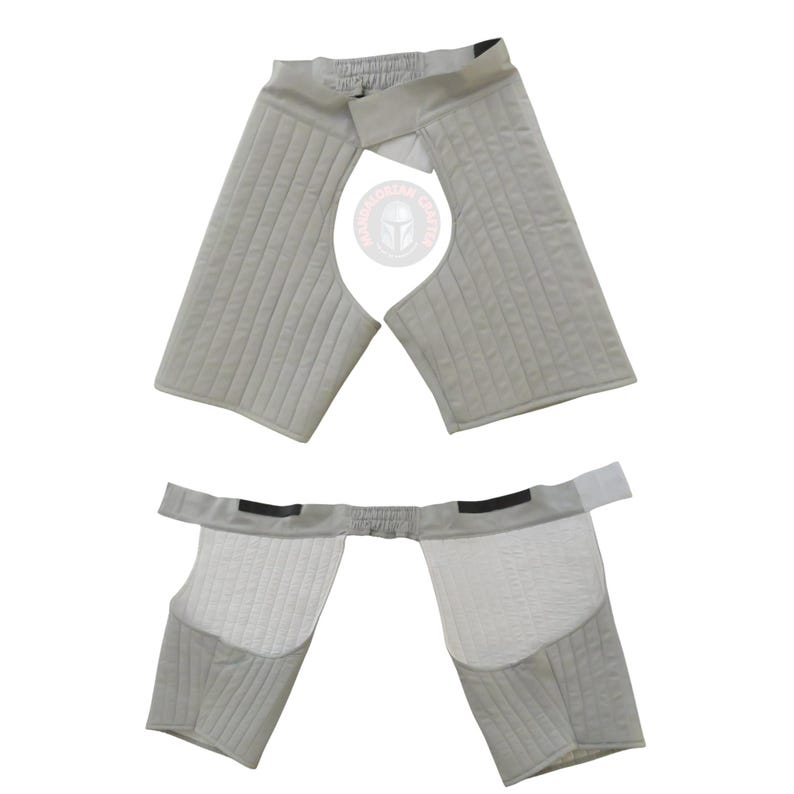 以下が含まれることがあります： 2 ピースの、明るい灰色のパッド入りアーマー。 上部には、伸縮性のあるベルクロ留めのウエストバンドが付いています。 下部は同様のデザインで、キルティングパッドとウエストストラップが付いています。 アーマーは保護と快適さのために設計されています。