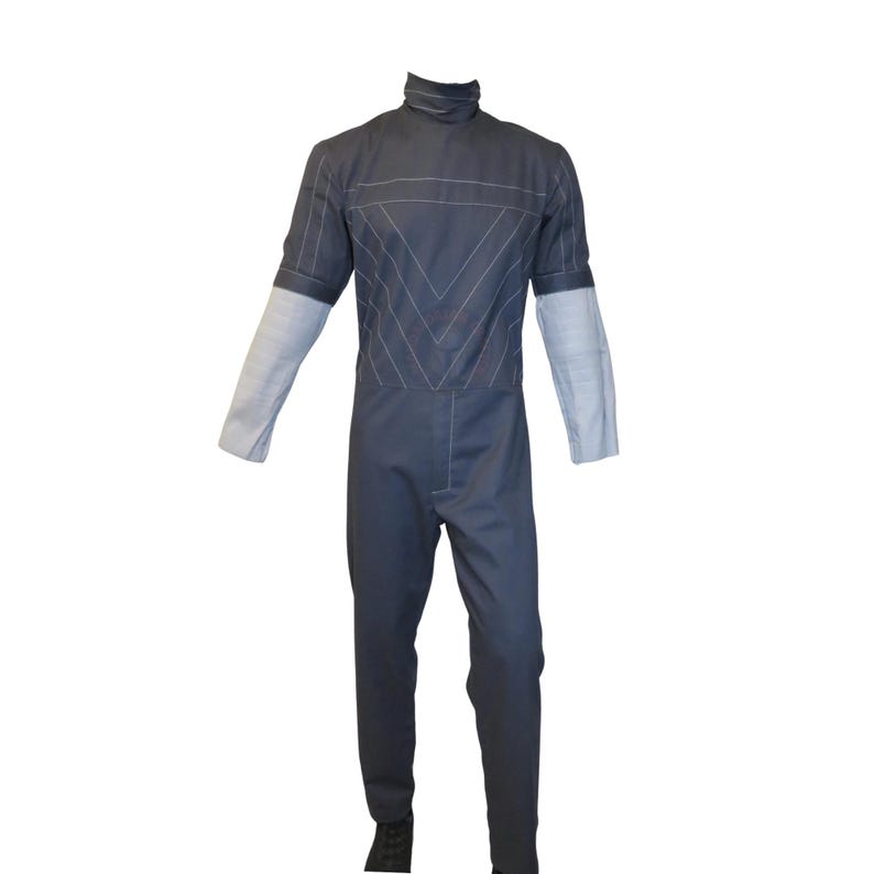 以下が含まれることがあります： ハイネックと長袖のダークグレーのジャンプスーツ。上部は白いステッチの幾何学模様が特徴です。袖はライトグレーです。ジャンプスーツは白い背景に表示されています。