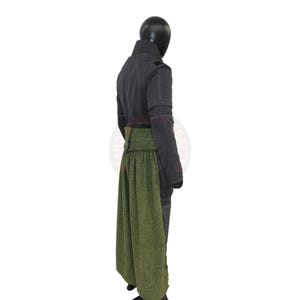 May include: A dark gray jacket with a high collar and a green skirt. The jacket has visible stitching and a buttoned closure. The skirt is a textured green fabric, creating a layered effect. The outfit is displayed on a mannequin.