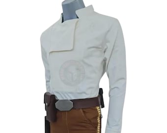 May include: A cream-colored jacket with a unique asymmetrical collar, paired with brown pants and a brown belt. The belt features a silver buckle and a holster. The outfit is displayed on a mannequin.
