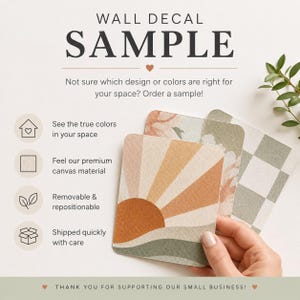 May include: Three rectangular wall decal samples with a canvas texture. The front sample features a sunburst design in orange, tan, and sage green. The other samples show a floral pattern and a sage green checkered pattern. Text reads WALL DECAL SAMPLE.