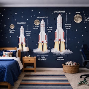 May include: A child's bedroom with a navy blue wall decorated with rocket and moon decals. The decals include a small rocket (36 inches high), a medium rocket (50 inches high), and a large rocket (66 inches high). The room also features a bed, a rug, and a desk.