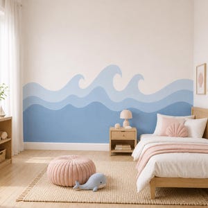 May include: A bedroom featuring a wall mural with layered blue ocean waves. The room includes a wooden bed frame with white and pink bedding, a shell-shaped pillow, a wooden nightstand with a lamp, a pink pouf, and a blue whale plush toy.