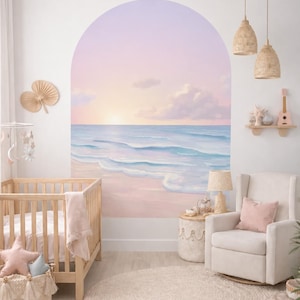 May include: A nursery decorated with a beach scene mural depicting a sunset over the sea. The room features a wooden cot, a rocking chair with a pink cushion, and woven pendant lights. A circular jute rug and a decorative basket complete the tranquil space.
