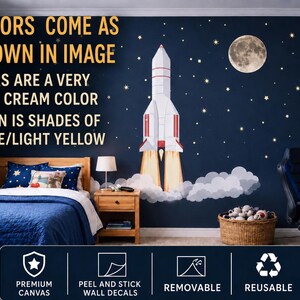 May include: A bedroom wall decorated with a rocket ship, stars, and a moon. The text on the wall says "COLORS COME AS SHOWN IN IMAGE" and "STARS ARE A VERY PALE CREAM COLOR MOON IS SHADES OF BEIGE/LIGHT YELLOW". The wall decals are peel and stick, removable, and reusable.