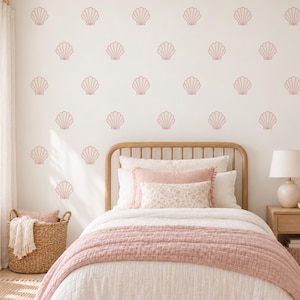 May include: A bedroom wall featuring a repeating pattern of dusty pink seashell wall decals. The room includes a wooden bed frame with white and pink bedding, a woven basket with a throw blanket, and a wooden nightstand with a lamp.