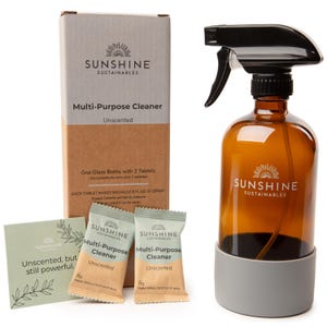 May include: An amber glass spray bottle with a black spray nozzle and a gray base, alongside a cardboard box and two packets of multi-purpose cleaner tablets. The box and packets display the "SUNSHINE SUSTAINABLES" logo and the words "Multi-Purpose Cleaner".