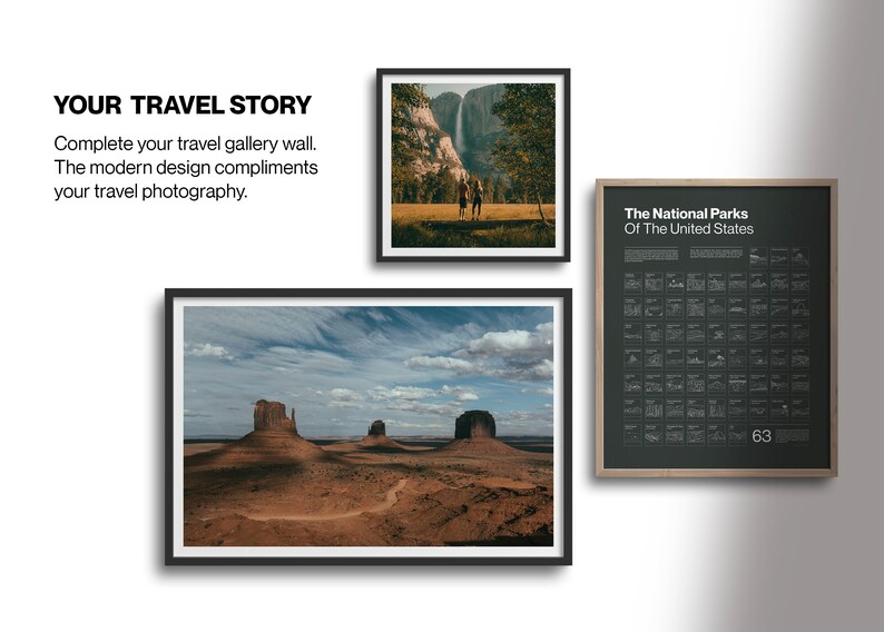 May include: A framed print of a landscape photograph featuring a desert scene with three rock formations in the distance. The sky is blue with white clouds. The print is in a black frame.