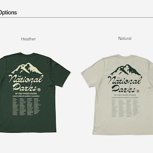 May include: Two t-shirts, one heather green and one natural, displaying the text "The National Parks" with a mountain graphic. The shirts also list the names of the National Parks. The shirts are short-sleeved.
