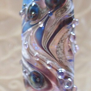 Peut inclure: Un bouchon de bouteille bleu et argent avec un motif tourbillonnant et une sph&egrave;re de verre transparente sur le dessus.