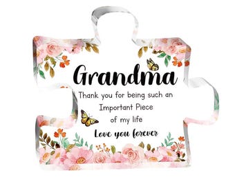 May include: A puzzle-shaped decorative item with the word "Grandma" in black script. The item features a floral design with pink roses and butterflies. Text reads "Thank you for being such an Important Piece of my life Love you forever."